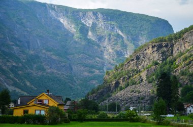 Renkli evleri ve Sognefjord dağ manzaralı güzel ve tipik Norveç köyü Flam.