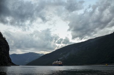 Büyük yolcu gemisi Flam limanından ayrılıyor. İskandinavya 'nın güzel doğası. Fiyort manzarasının manzarası. 