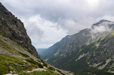 Slovakya 'daki dağ manzarası, kayalık dağ vadisi ve ulusal park High Tatras' ta bulutlu gökyüzü ile kayalara tırmanma