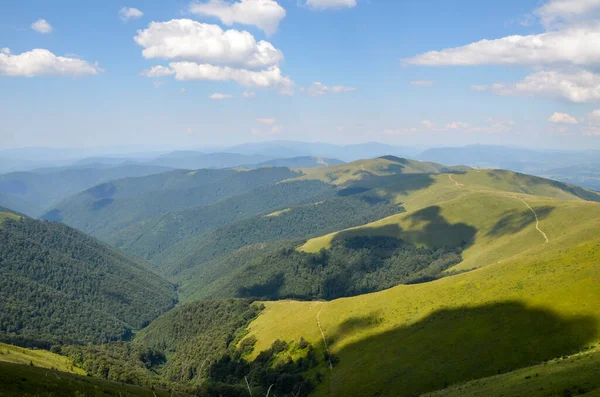 Güneşli bir yaz gününde, yuvarlanan çimenli tepelerle Borzhava dağlarının güzel dağlık manzarası