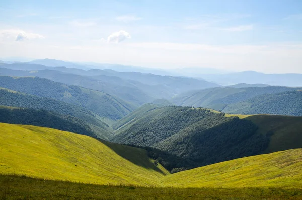Güneşli bir yaz gününde, yuvarlanan çimenli tepelerle Borzhava dağlarının güzel dağlık manzarası