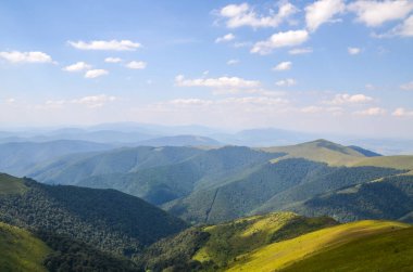 Dağlar boyunca uzanan beyaz yaz bulutları yeşil ormanı ve otlak yamaçları kaplıyordu. Borzhava dağ sıraları, Ukrayna 'nın popüler seyahat merkezleri. Karpat Dağları