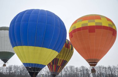 KYIV, UKRAINE - 20 Şubat 2021: Birçok renkli sıcak hava balonu Ukrayna 'nın başkenti Kyiv' de havacılık festivaline kalkıyor ve iniyor