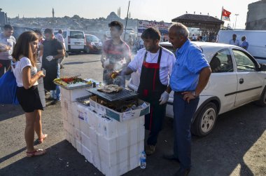 ISTANBUL, TURKEY AĞUSTOS 12, 2015: Şef sıcak uskumru balığı sandviçi hazırlıyor, Balik Ekmek. İstanbul, Türkiye 'de geleneksel Türk sokak yemekleri