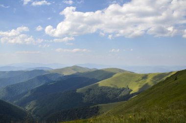 Görkemli dağ sıraları ve yeşil yemyeşil çimlerle kaplı yuvarlanan tepeler, çalılar. Borzhava, Karpat Dağları, Ukrayna