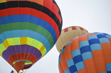 Birçok renkli sıcak hava balonu Ukrayna 'nın başkenti Kyiv' de havacılık festivaline kalkıyor ve iniyor.
