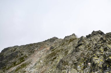 View of mount Rysy tly covered with clouds in the High Tatra Mountains on the border between Poland and Slovakia.