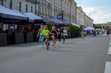 KYIV, UKRAINE - 22 Mayıs 2021: Güneşli bir günde sokakta koşan mutlu küçük kızlar