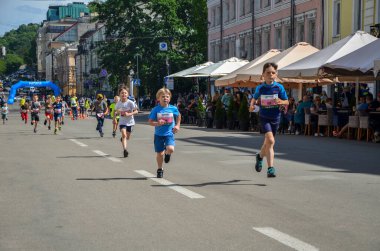 KYIV, UKRAINE - 22 Mayıs 2021: Ukrayna 'nın başkenti Kyiv' de koşan çocuklar arasında şehir sokaklarında yarışan genç çocuklar. Yaz yarışı ya da maraton. 