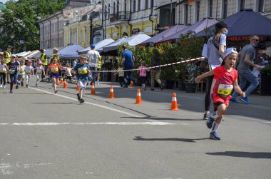 KYIV, UKRAINE - 22 Mayıs 2021: Güneşli bir günde sokakta koşan mutlu küçük çocuklar