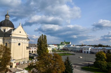 ZHOVKVA, UKRAINE - 20 Ekim 2020: Meydandaki evler ve tarihi Zhovkva, Lviv bölgesi, Ukrayna merkezindeki St. Lawrence Kilisesi.