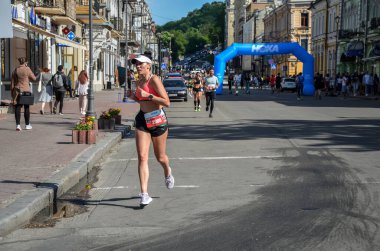KYIV, UKRAINE - 22 Mayıs 2021: Maraton koşucuları şehir yolunda koşuyor. Sağlıklı yaşam tarzı, spor hobisi. Sokak maratonu, açık hava koşusu, yarışma