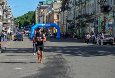 KYIV, UKRAINE - 22 Mayıs 2021: Maraton koşucuları şehir yolunda koşuyor. Sağlıklı yaşam tarzı, spor hobisi. Sokak maratonu, açık hava koşusu, yarışma