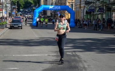 KYIV, UKRAINE - 22 Mayıs 2021: Birçok koşucu spor giyim ve koşu ayakkabılarıyla şehir sokaklarında maraton boyunca koşuyor