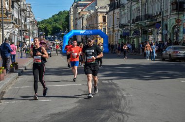 KYIV, UKRAINE - 22 Mayıs 2021: Birçok koşucu spor giyim ve koşu ayakkabılarıyla şehir sokaklarında maraton boyunca koşuyor
