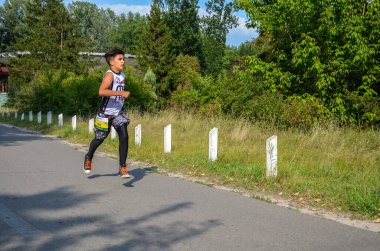 KYIV, UKRAINE - 24 Temmuz 2021: Koşan çocuklar, koşan gençler, koşan atletler, şehir yolunda koşan, sabah ışığında koşan sporcular