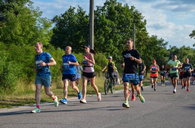 KYIV, UKRAINE - 24 Temmuz 2021: Koşucular açık havada koşuyor. Kentsel alanda yarışan sportif insanlar, sağlıklı yaşam tarzı ve spor kavramları.