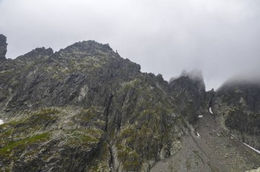 Slovakya 'daki High Tatras dağlarındaki yüksek dağ zirvelerinin üzerinden sis ve yağmur bulutları