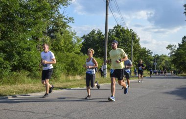KYIV, UKRAINE - 24 Temmuz 2021: Şehirde koşu maratonu sırasında birçok sporcu. fitness ve sağlıklı yaşam tarzı konsepti 