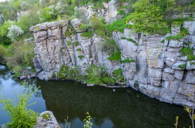 Kayalık kanyonun doğa manzarası ve Ukrayna 'nın Buky köyünde su yansıması olan sakin bir nehir.
