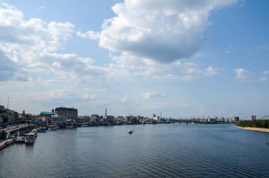 KYIV, UKRAINE - 24 Temmuz 2021: Podil ilçesinin Dnipro nehir setinin kıyısındaki yaya köprüsünden görüntü. Kyiv, Ukrayna