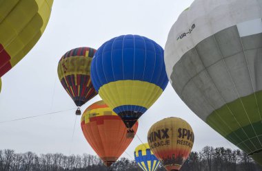 KYIV, UKRAINE - 20 Şubat 2021: Kyiv Balon Festivali 'nde gökyüzüne karşı birbirlerine çok yakın renkli sıcak hava balonları  