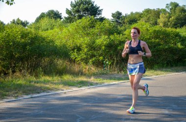 KYIV, UKRAINE - 24 Temmuz 2021: Genç bayanlar maraton yarışında yarışıyor. Şehir parklarında ve caddelerde koşu yarışı.