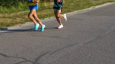 Bir yarışta koşucuların bacakları ve ayakları görünüyor. Fitness ve egzersiz. Sağlıklı ve yaşam tarzı.