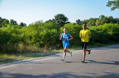 KYIV, UKRAINE - 24 Temmuz 2021: Şehir maratonu sırasında açık havada koşan bir grup genç sporcu. Sokakta spor yapıyor. Sağlıklı yaşam tarzı kavramı.