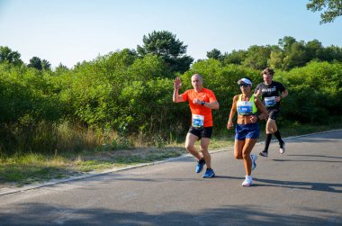 KYIV, UKRAINE - 24 Temmuz 2021: Şehir maratonu sırasında açık havada koşan bir grup genç sporcu. Sokakta spor yapıyor. Sağlıklı yaşam tarzı kavramı.