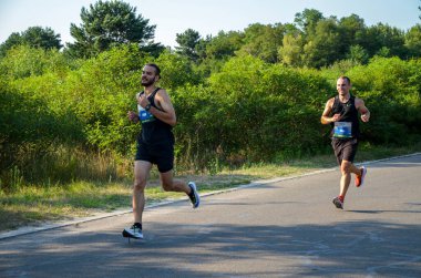 KYIV, UKRAINE - 24 Temmuz 2021: Şehir maratonu sırasında açık havada koşan bir grup genç sporcu. Sokakta spor yapıyor. Sağlıklı yaşam tarzı kavramı.