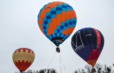KYIV, UKRAINE - 20 Şubat 2021: Kyiv Balon Festivali 'nde gökyüzüne karşı birbirlerine çok yakın renkli sıcak hava balonları  