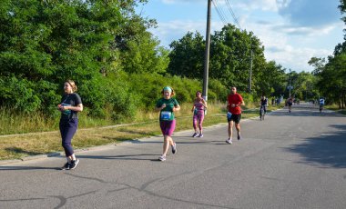 KYIV, UKRAINE - 24 Temmuz 2021: Grup sporcuları şehir maratonunda koşan erkek ve kadınlar. Fitness ve sağlıklı aktif yaşam tarzı