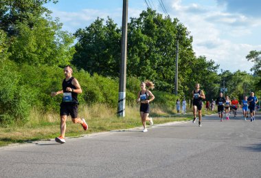 KYIV, UKRAINE - 24 Temmuz 2021: Grup sporcuları şehir maratonunda koşan erkek ve kadınlar. Fitness ve sağlıklı aktif yaşam tarzı