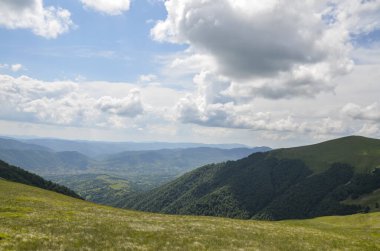 Dağ tepeleri ve çayırlar ile güzel dağ manzarası bulutlu gökyüzünün altında yeşil çimenler ve ormanlar kaplıydı. Karpat Dağları, Ukrayna