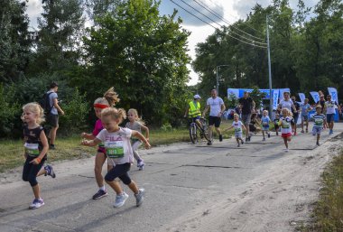 KYIV, UKRAINE - 24 Temmuz 2021: Çocuklar ve ebeveynler yaz aylarında parkta yapılan aile koşu yarışmaları sırasındaki mesafeler. Spor ailesi. Sağlıklı yaşam tarzı.