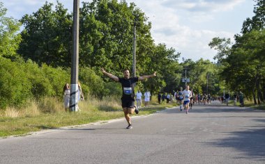 KYIV, UKRAINE - 24 Temmuz 2021: koşucular duygularını gösteren bir fotoğraf için poz veriyorlar ve yarışma sırasında koşmaktan zevk alıyorlar. Spor ve aktif yaşam tarzı