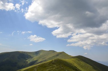 Dağ sırası boyunca yürüyüş yolu. Çimenli dağlık yamaçlardan geçen yol. Karpatların güzel manzarası Ukrayna