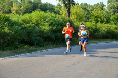 KYIV, UKRAINE - 24 Temmuz 2021: Bir grup sporcu şehir maratonunda koşuyor. Spor, spor ve sağlıklı yaşam tarzı konsepti