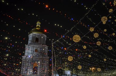 Açık havada ışıklarla süslenmiş Noel ağacı ve Kyiv 'de arka planda Aziz Sophia Katedrali. Yeni Yıl Kutlaması