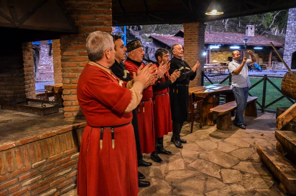 KVARELI, GEORGIA - 9 Ekim 2019: Üzüm hasat festivali sırasında ulusal kostümlü Gürcü erkekler şarkı söylüyorlar
