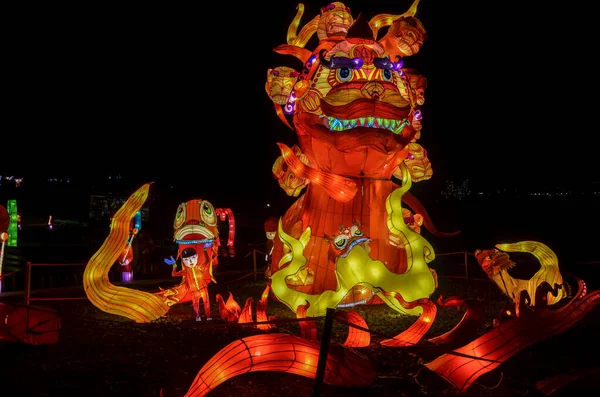 Traditional lamps from the Chinese Lantern Festival in honor of the New Year. Sculpture depicting a red dragon with street lighting