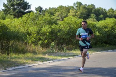 KYIV, UKRAINE - 24 Temmuz 2021: Maraton koşucuları şehir yolunda koşuyor. Sağlıklı yaşam tarzı, spor hobisi. Sokak maratonu, açık hava koşusu, yarışma