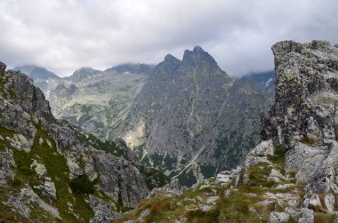Kayalık dağ sırtı ve bulutların gizlediği keskin tepeleri olan bir manzara. Yüksek Tatras, Slovakya