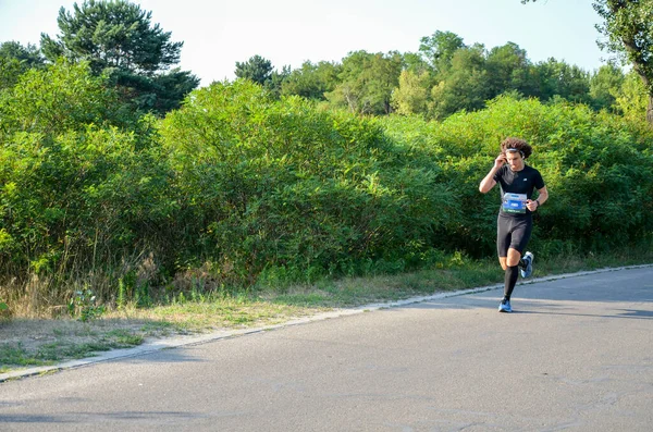 KYIV, UKRAINE - 24 Temmuz 2021: Şehir yolunda koşan sağlıklı insanlar. Sağlıklı kilo vermek ve kardiyo eğitimi almak için harika egzersizler.