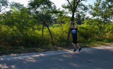 KYIV, UKRAINE - 24 Temmuz 2021: Spor giyim ve koşu ayakkabıları ile koşucu şehir sokaklarında maraton boyunca. Fitness ve sağlıklı yaşam tarzı konsepti 