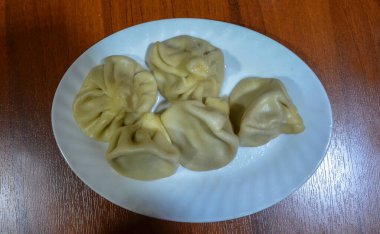 Beyaz tabakta et ve otlu Khinkali hamur tatlısı. Geleneksel Gürcü mutfağı.