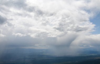 Dağlar arasındaki vadide sisli yağmur ve fırtına bulutlarının panoramik manzarası