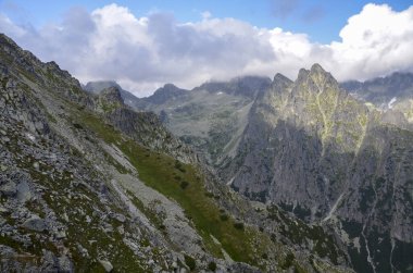 Slovakya 'da yaz aylarında yüksek Tatra dağlarının alçak bulutlarını kaplayan kayalık tepelerin manzarası. Slavkovsky Dağı 'na giden patika 