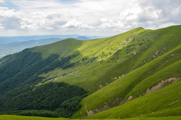 Resimli Karpat Dağları dağ sırtında dik yeşil yamaçlarıyla bulutlu bir gökyüzünün altında 